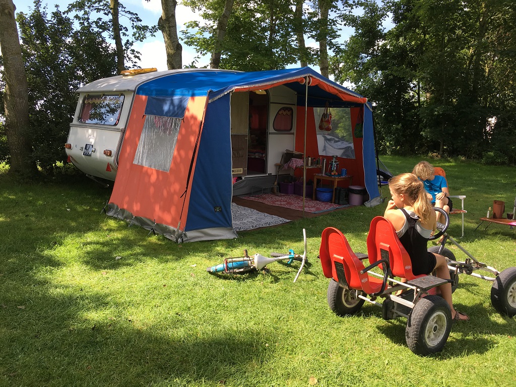 kleurrijke caravan onder de bomen